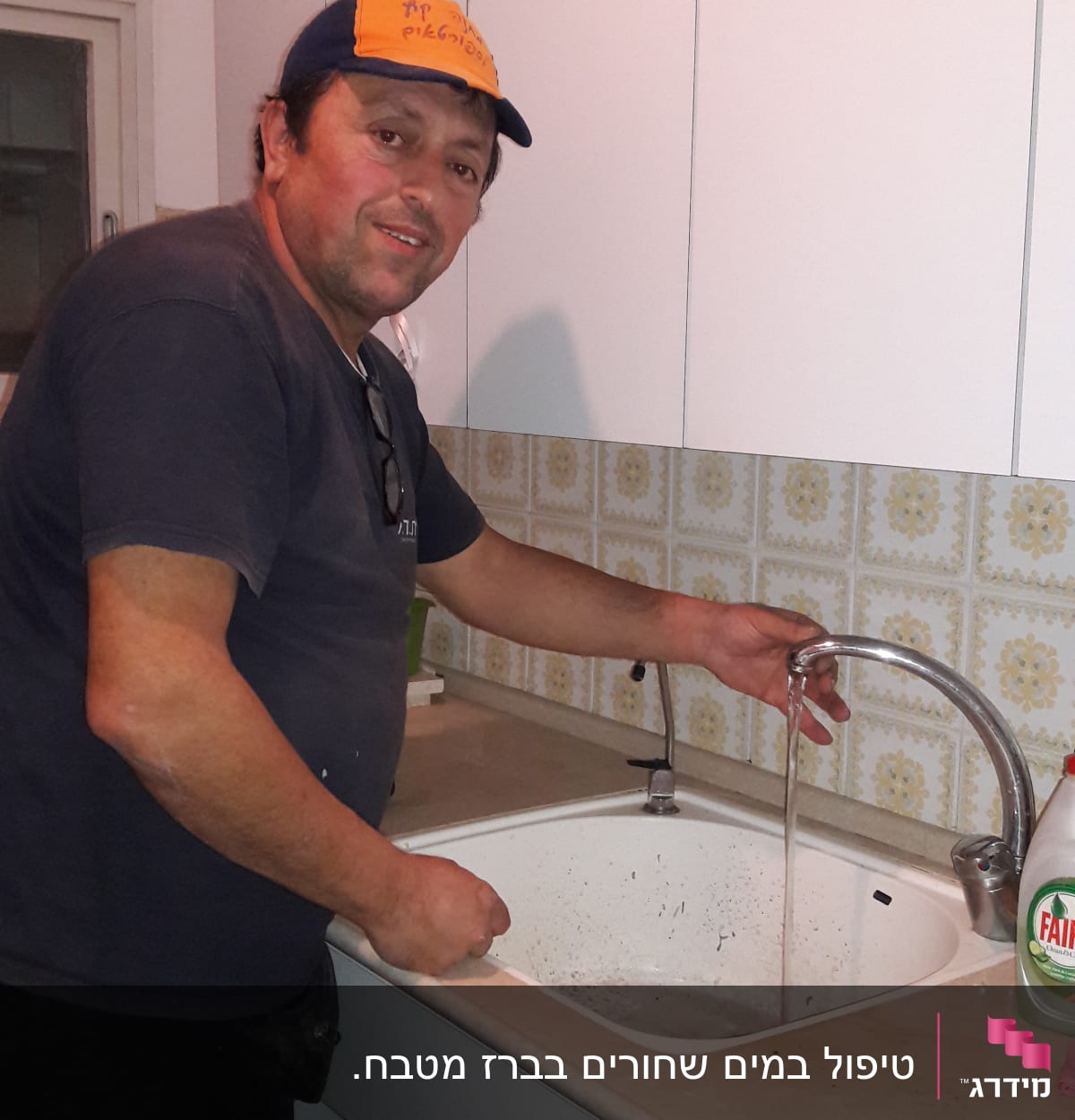 אדם בודק ברז מים בכיור מטבח